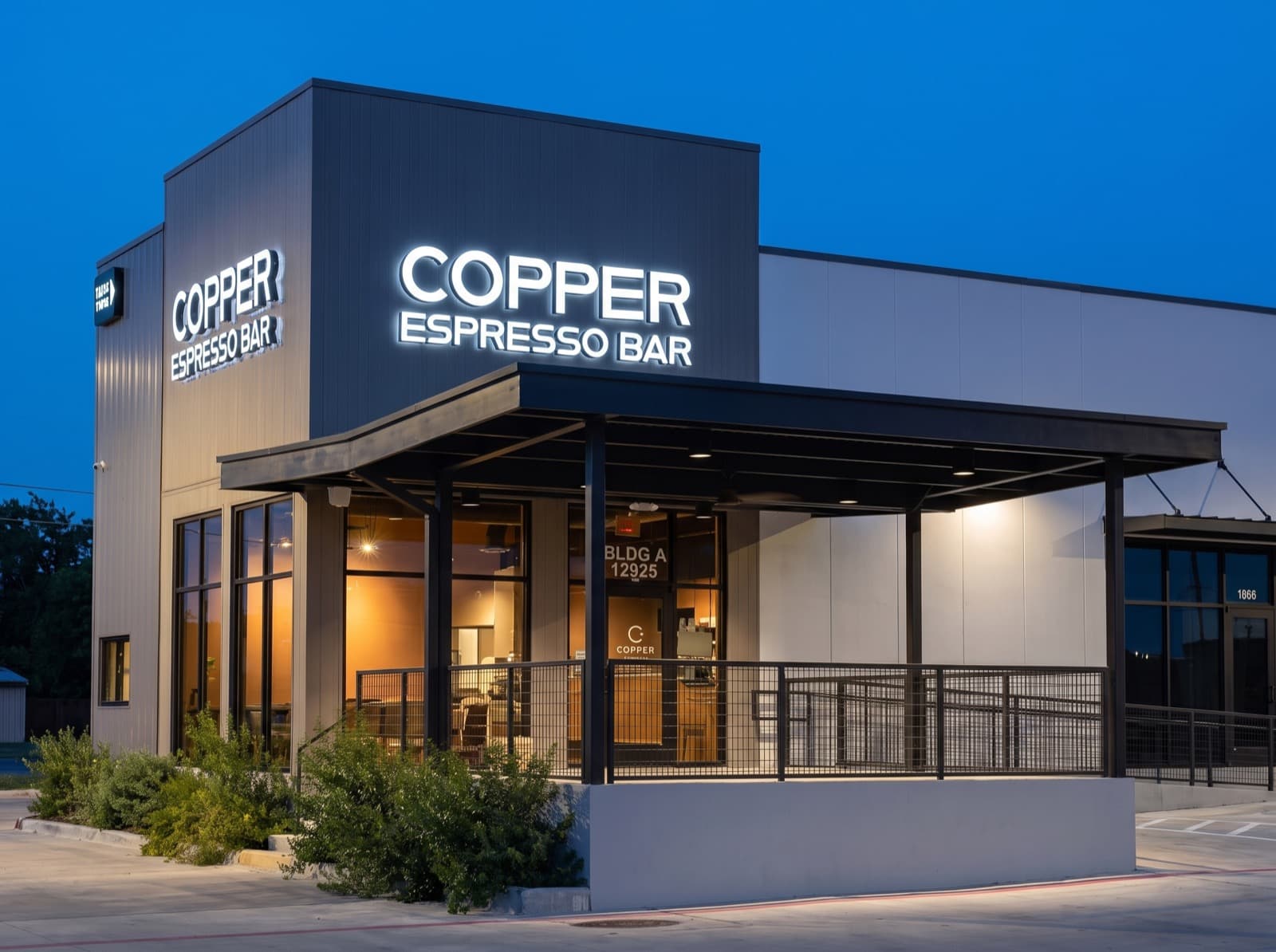 Backlit exterior sign for Copper Espresso Bar, installed above a storefront at dusk